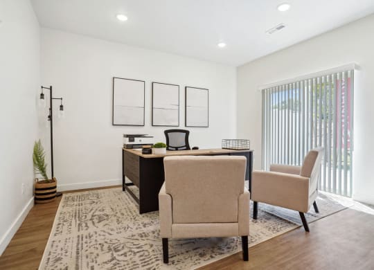 an office with two chairs and a desk and a window