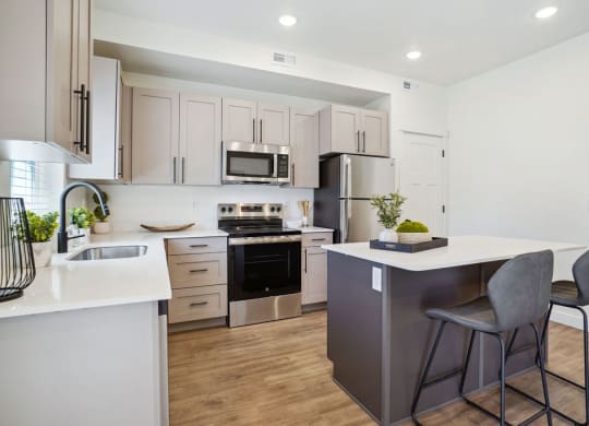an open kitchen with an island with two stools