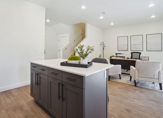 a kitchen with an island and a living room with a desk