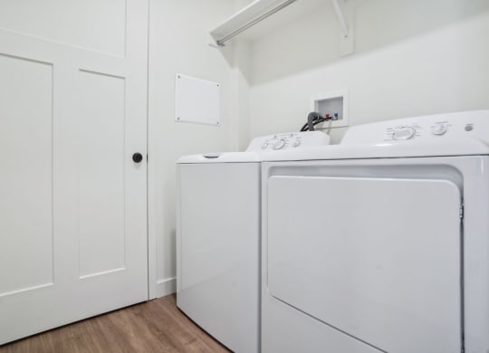 a laundry room with a washer and dryer and white cabinets