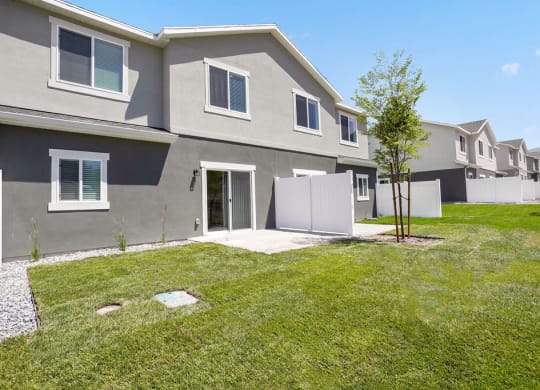 a row of houses with grass and trees in front of them