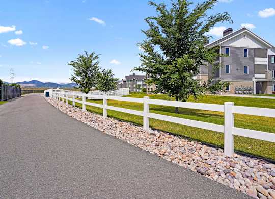 Affinity 56 Apartments for rent in West Jordan, UT  A white fence runs along a paved road.