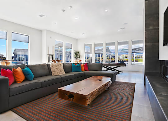 A modern living room with a grey couch and a wooden coffee table.
