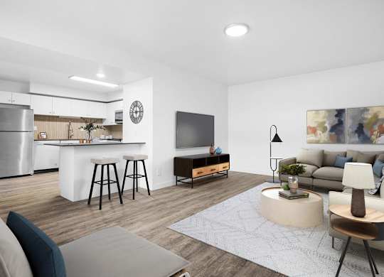 A modern living room with a kitchen area in the background.