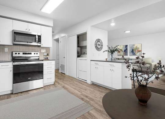 A modern kitchen with white cabinets and stainless steel appliances.