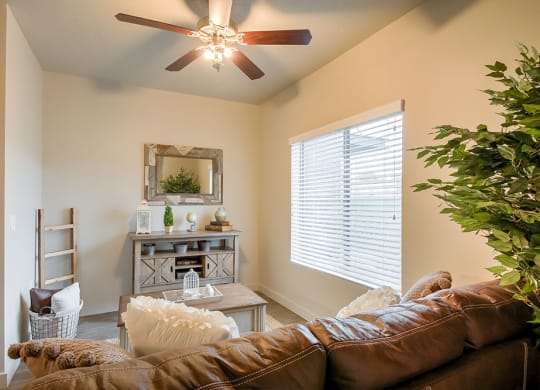 a living room with a ceiling fan and a large window