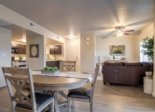 an open floor plan with a dining table and chairs and a living room with a couch and