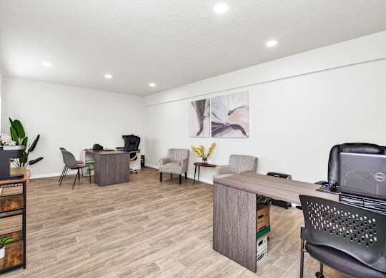 A room with a desk and chairs.