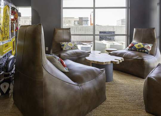 a living room with leather chairs and a window