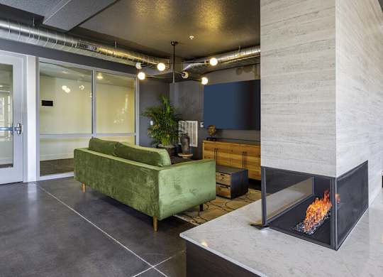 a living room with a fireplace and a green couch