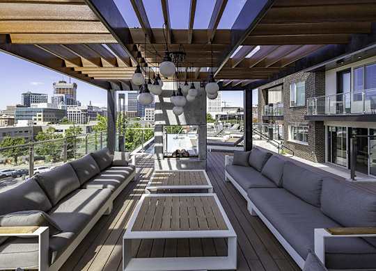 a patio with couches and tables on a roof