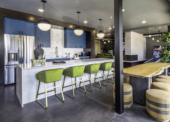 a kitchen with green bar stools and blue cabinets