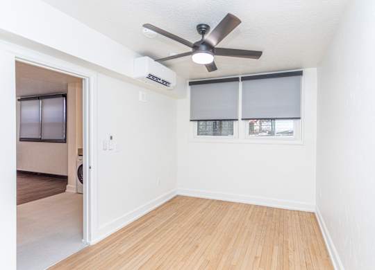 an empty room with a ceiling fan and a window