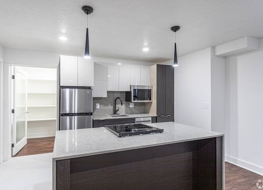 a kitchen with white cabinets and a large island with a stove and