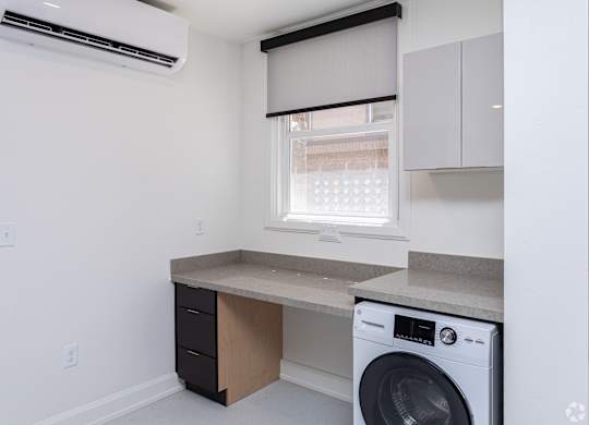 an empty kitchen with a washing machine and a window