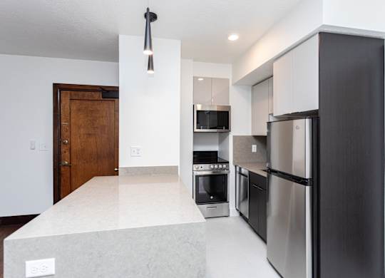 a kitchen with stainless steel appliances and a white counter top