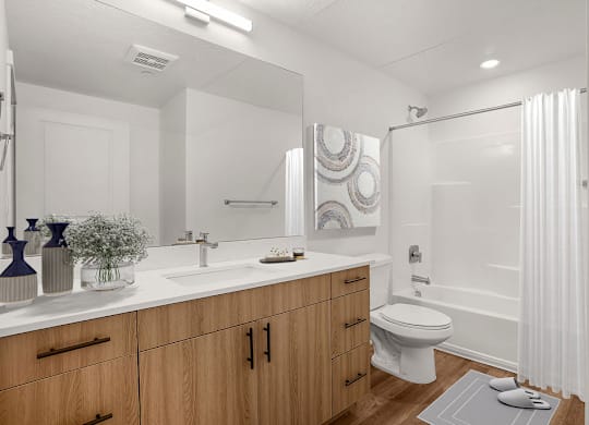 A bathroom with a white toilet, sink, and shower.