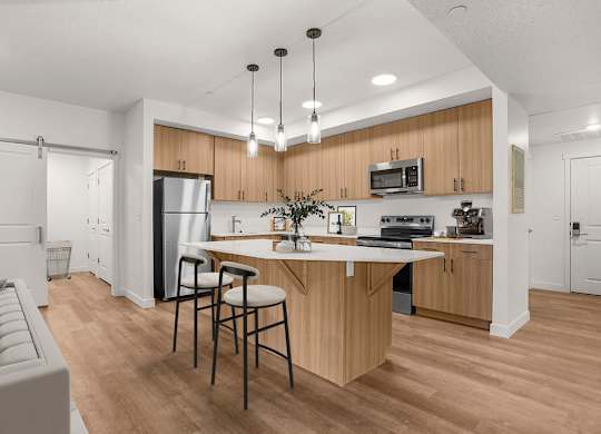 A modern kitchen with wooden cabinets and a white island.