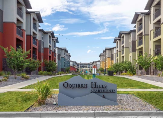 an exterior view of an apartment complex with a sign that reads quorum hills apartments