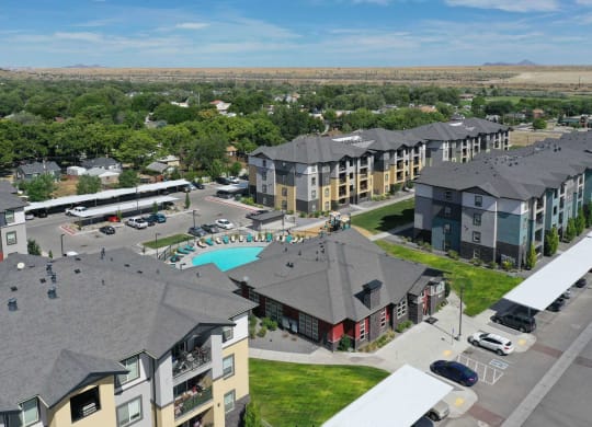 an aerial view of a large apartment complex with a pool and parking lot
