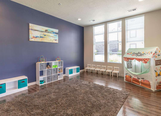 a playroom with a play table and chairs and a large window