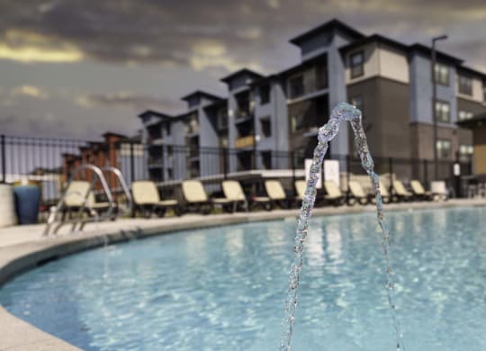 a pool with a faucet in front of a building