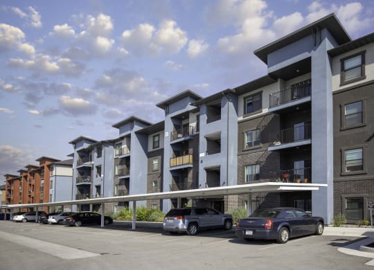 a rendering of an apartment building with cars parked in front of it
