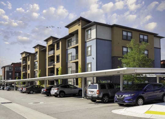 a rendering of an apartment building with cars parked in front of it