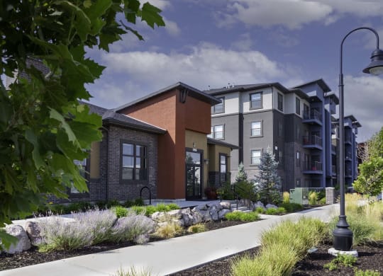 a rendering of an apartment building with a sidewalk in front of it