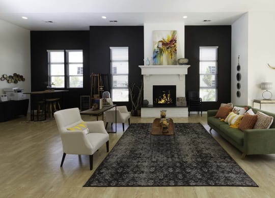 a living room with a green couch and two white chairs in front of a fireplace
