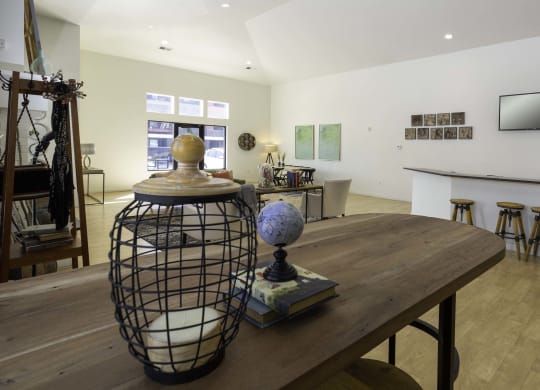 a large room with a wooden table and a black cage with a globe on top of it