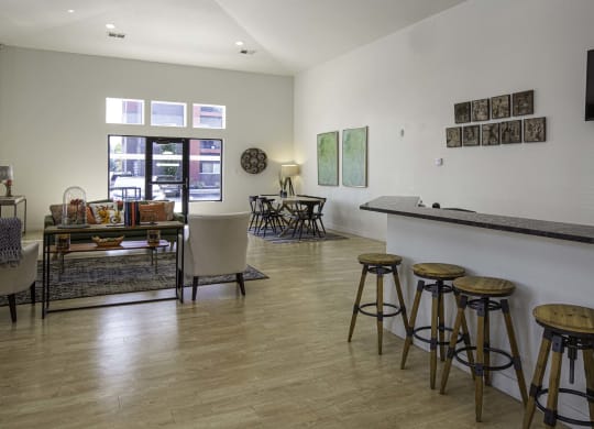 a living room with a bar and a dining room in the background