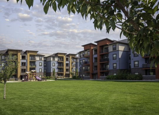picture of an apartment building with a playground in the foreground