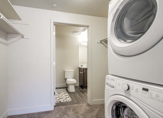 a washer and dryer in a bathroom with a toilet