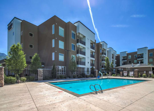 an outdoor swimming pool with an apartment building in the background