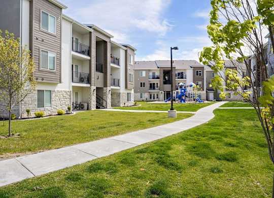 Apartment complex with a walkway in front.