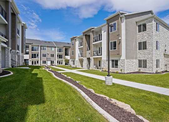 Apartment complex with a grassy area in front.