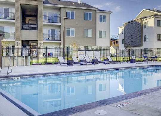 A swimming pool in front of apartment buildings.