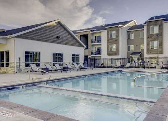 A swimming pool in front of apartment buildings.