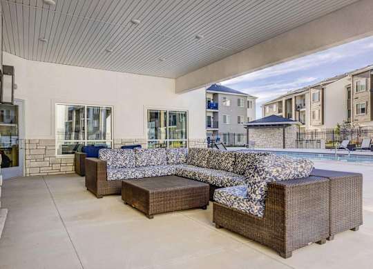 A modern outdoor seating area with a large couch and a coffee table.