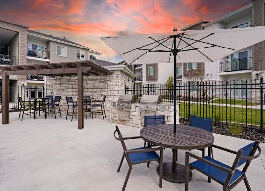 A patio with a table and chairs is set up outside a building.