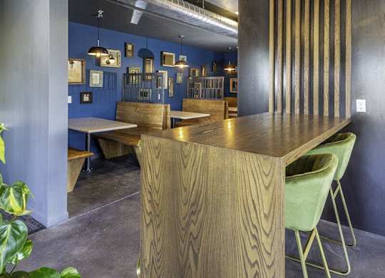 A long wooden table with green chairs in a room with blue walls.