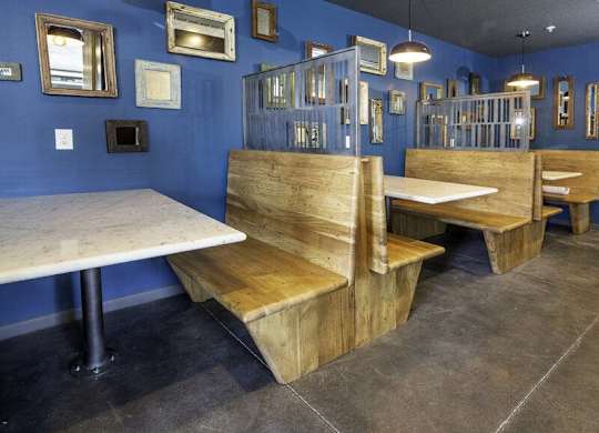 A blue room with wooden benches and tables.