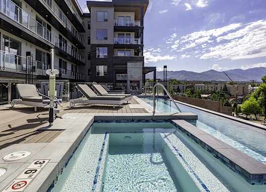 A large outdoor swimming pool with a mountain view in the background.