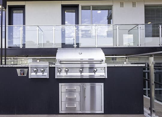 A modern outdoor kitchen with a grill and oven.