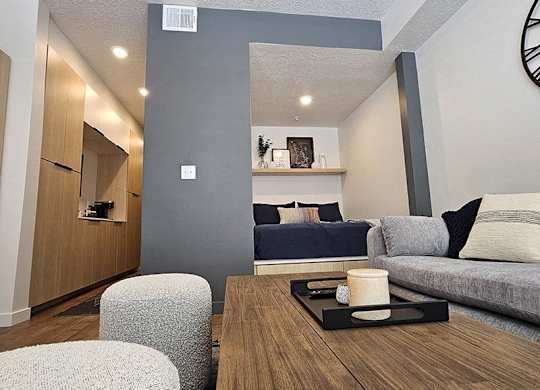 A modern living room with a grey couch and a wooden coffee table.