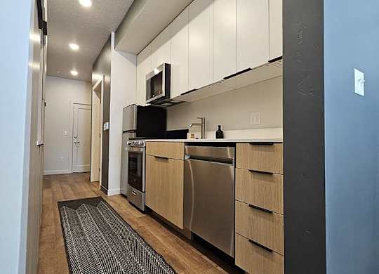 A kitchen with a black fridge and white cabinets.