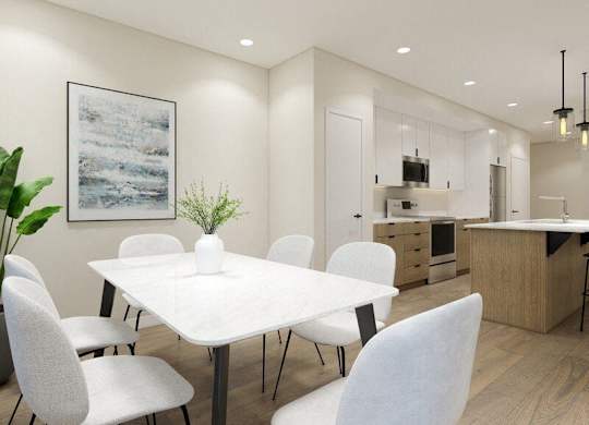 A modern dining room with a white table and chairs.