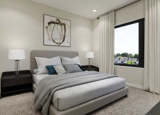 A bedroom with a large bed, two lamps, and a framed picture on the wall.