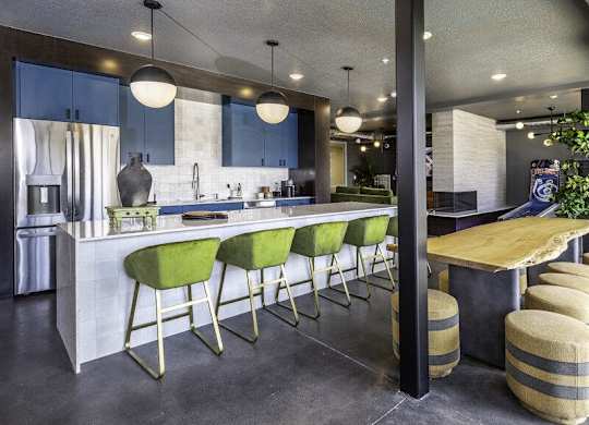A kitchen with green bar stools and a white counter.
